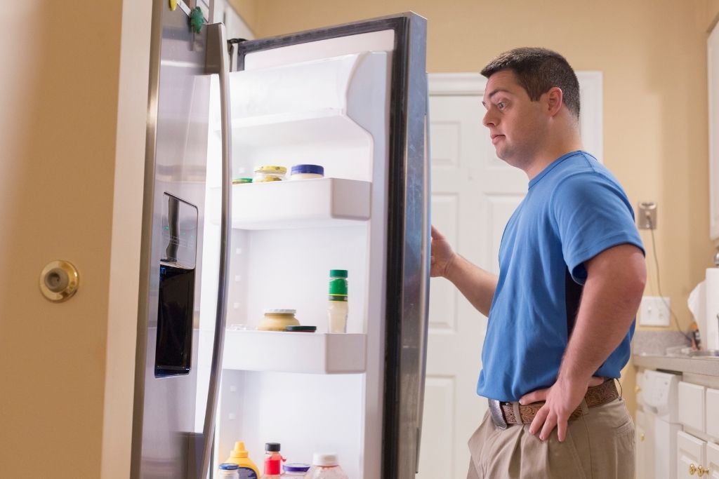 мужчина открывает холодильник